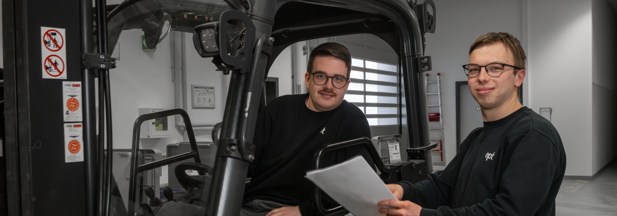 Zwei Männer im Gabelstapler.